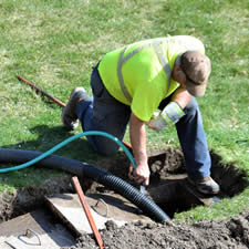 image of a worker draining septic system related to appraisal expert work - Article for Appraisers
