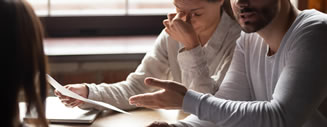 Unhappy couple scrutinizing a real estate appraisal document