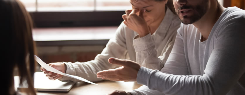 Unhappy couple scrutinizing a real estate appraisal document